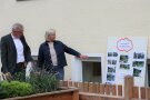 Mann und Frau neben Schautafel mit historischen Bildern.