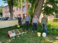 Vier Männer in schattigem Garten mit vier Kisten für Versuchsaufbau.