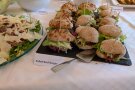 Zahlreiche Burger auf Tabett auf einem Speisenbuffet.