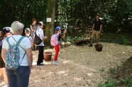Gruppe von Kindern steht in einer Reihe, das vordere versucht einen Weitwurf mit einem Fichtenzapfen.
