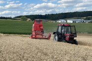 Traktor und landwirtschaftliche Maschine auf einem Getreidefeld im Einsatz.